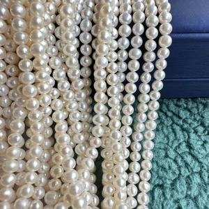 Macro shot of 4-5mm white freshwater pearls showing natural luster and smooth round surface