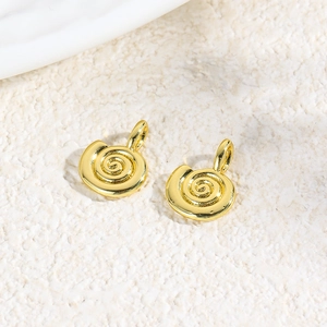 Macro shot of two golden spiral shell charms for DIY jewelry making and necklace crafts
