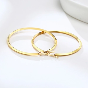 Detailed view of large gold hoop earrings with a high-polished metallic finish