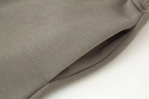 Detailed view of the taupe knitted cotton fabric and hidden side pocket of the tracksuit