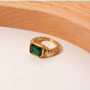 Detail of 18K gold plated rope twist band ring with rectangular emerald green gemstone