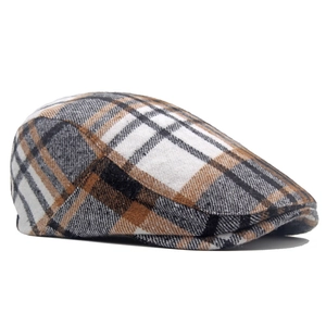 Detail shot of the brown plaid wool fabric and stitching on this classic flat cap