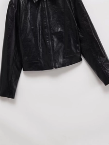 Detailed macro view of black faux leather texture and smooth metal zipper on a biker jacket