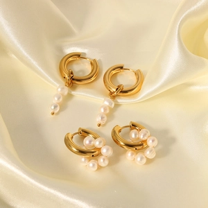 Boucles d'oreilles en acier doré 18K et perles d'eau douce sur fond de soie