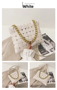 Detail of white woven handbag with chunky gold chain strap and square braided texture