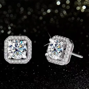 Detailed close-up of luxury square pavé stud earrings with round center stones on black