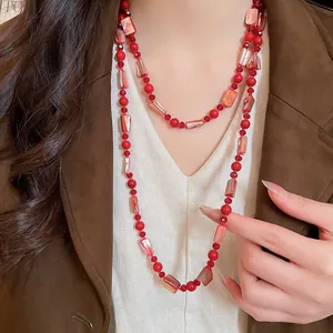 Detail of bohemian red crystal and shell beaded double-layered necklace on model