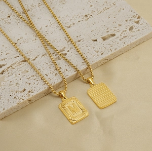 Detailed view of 18K gold stainless steel square pendant featuring M initial and box chain