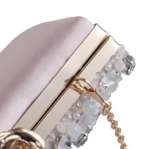 Dettaglio della borsa da sera con strass, perline e chiusura a rosa dorata