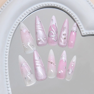 Pink cat eye press-on nails with 3D silver bow and star accents in stiletto shape
