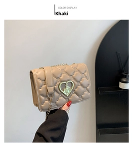 Détail du petit sac carré matelassé kaki avec fermoir cœur doré et bandoulière chaîne