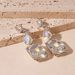 Gros plan de boucles d'oreilles en argent avec cristaux scintillants taille poire et rectangle