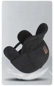 Detail of grey herringbone winter cap with earmuffs and a soft feather on grey background