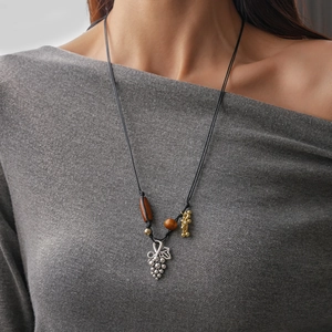 Détail du collier pendentif raisin argenté avec perles en céramique sur cordon noir