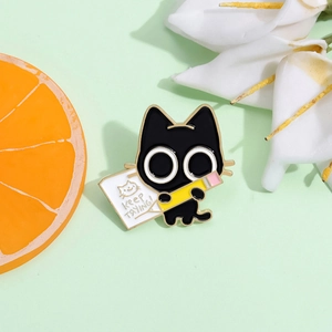 Detail of cartoon black cat enamel pin holding a pencil with Keep Trying text
