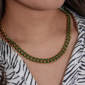 Close-up of gold and green enamel Cuban link chain necklace on a model wearing zebra print