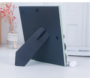 Detail view of the pale green picture frame back showing the stand and hanging hook