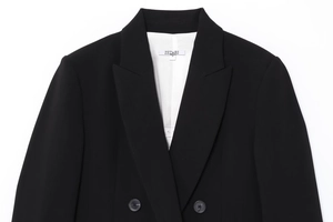 Détail du revers et des boutons d'un blazer noir croisé classique en tissu fluide