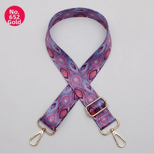 Close-up of geometric pattern webbing strap with golden metal lobster clasps and buckle