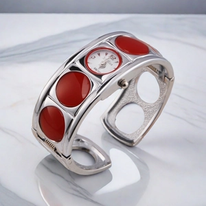 Silberne Quarz-Armreif-Uhr für Damen mit roten Akzenten auf Marmor-Hintergrund