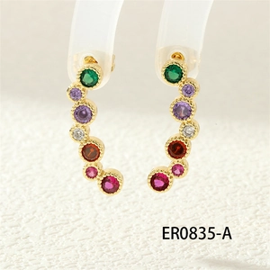 Macro shot of elegant gold stud earrings with colorful faceted cubic zirconia stones