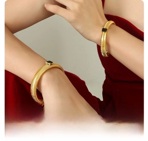 Detail of 18K gold plated titanium cuff bracelet featuring rectangular black gemstones