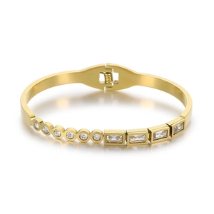 Elegant gold bangle with alternating round and rectangular white zircons on white background
