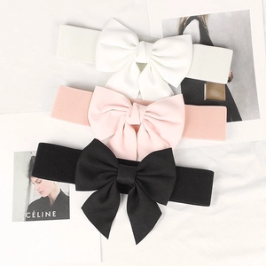 Detailed view of elastic corset belts with oversized bows in white, pink, and black colors