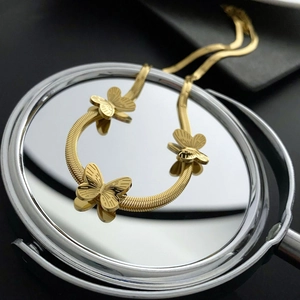 Collier élégant en acier titane doré avec trois pendentifs papillons et chaîne serpent