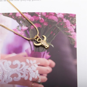 Gold bull head pendant necklace with micro-set cubic zirconia on a classic box chain