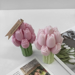 Detail of pink tulip candle with green stem and handmade tag on white background