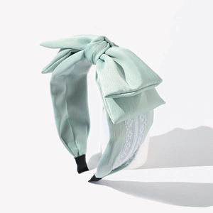 Light green satin bow headband with white lace trim and non-slip wide edge design