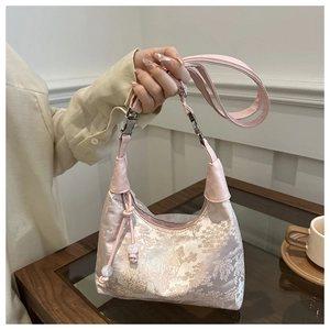 Detail of pink jacquard handbag with Chinese landscape pattern and bead tassel decoration