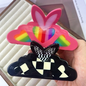 Pink rabbit-ear hair claw with rainbow hearts and black checkerboard heart clip