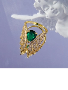 Macro shot of wing-shaped ring with green teardrop zircon and clear crystal accents