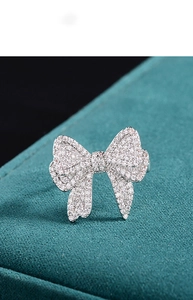 Close-up of sparkling zircon bow ring with micro-pave setting on premium velvet base