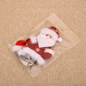 Detail of Santa Claus plush ornament with golden cord in protective packaging