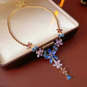Vue détaillée du collier vintage avec fleurs en cristal et pompon sur métal doré