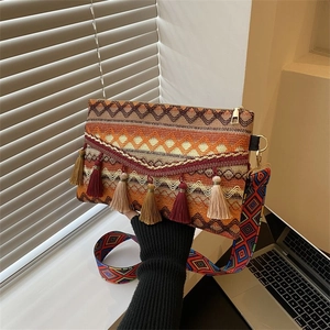 Bohemian woven crossbody bag featuring vibrant geometric patterns and colorful tassels