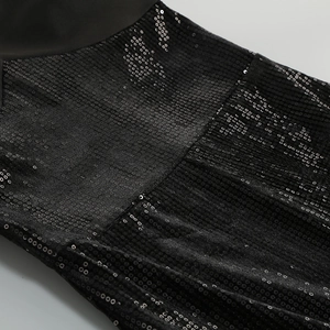 Detail of shimmering black sequins and fabric stitching on a sleek halter neck dress