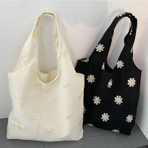 Minimalist canvas tote bag featuring daisy embroidery in white and black styles