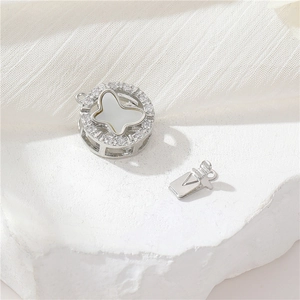 Silver pendant box with zircon pavé and white mother-of-pearl butterfly design on a stone base