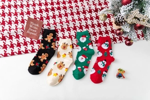 Detailaufnahme der Strickstruktur von vier Paar festlichen Weihnachtssocken mit Rentieren