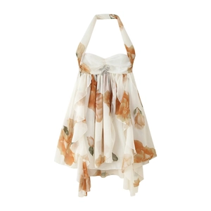 Detail of floral halter dress with backless cut, ruffles and star metal brooch detail