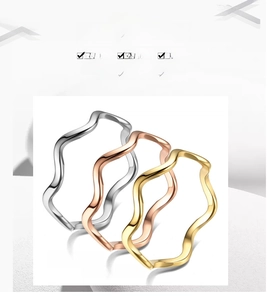 Detailed view of three minimalist wave stackable rings in gold silver and rose gold
