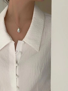Close-up of minimalist S925 sterling silver waterdrop pendant necklace on model