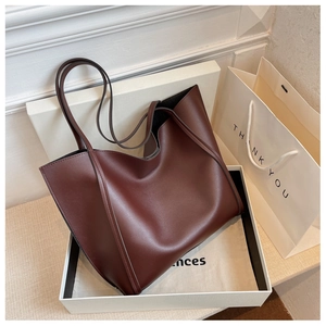 Detail of dark red vintage tote bag in elegant gift box with minimalist leather texture