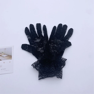 Detail of elegant black lace full finger gloves with vintage floral ruffle wrist trim