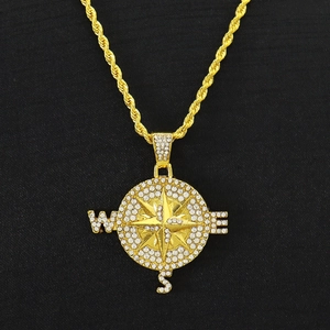 Gros plan du pendentif boussole doré serti de diamants sur une chaîne en corde noire