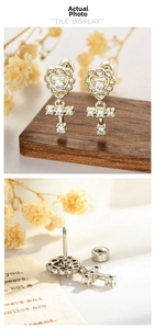 Detailed macro view of heart cross earrings with zirconia inlay and threaded screw back